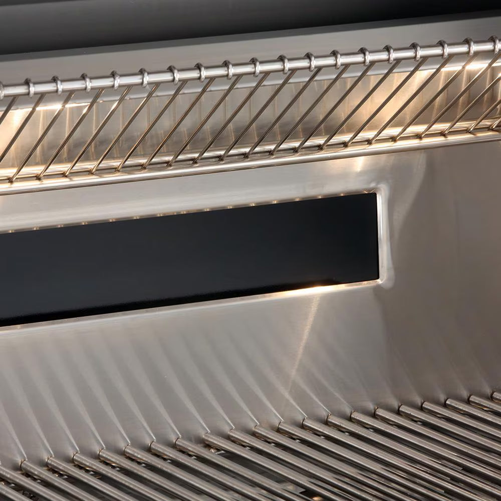 Close-up of the interior of a stainless steel grill showing the warming rack at the top, a recessed rear infrared burner housing, and the cooking grates below