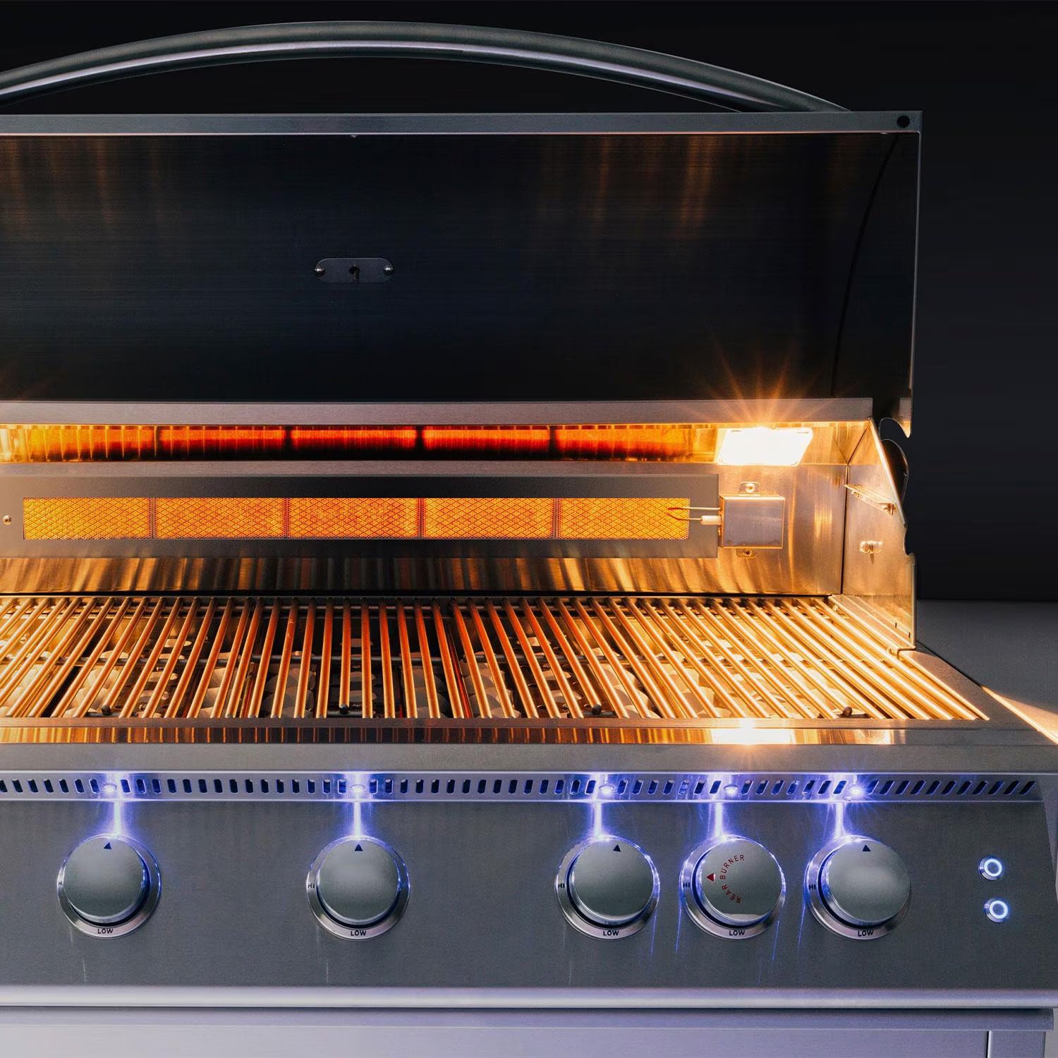 Summerset built-in gas grill with hood open showing a glowing infrared sear burner, red-hot grates and blue LED-lit control knobs on a black background