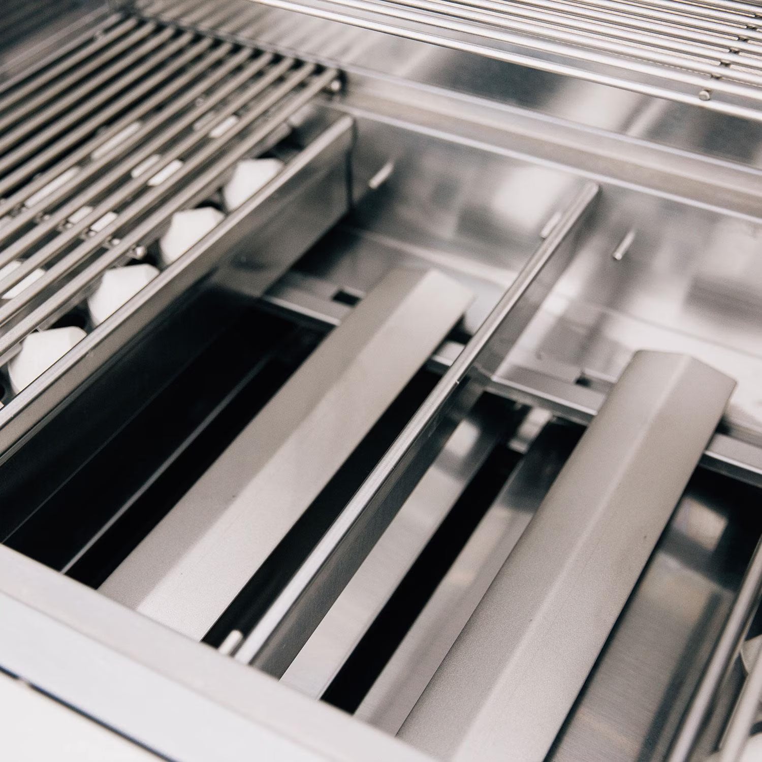 Interior showing the stainless steel flame tamer plates and cooking grates of a Summerset built-in gas grill
