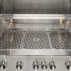 Front interior view of an open Coyote stainless steel grill showing the cooking grates, the warming rack above and a row of control knobs along the bottom