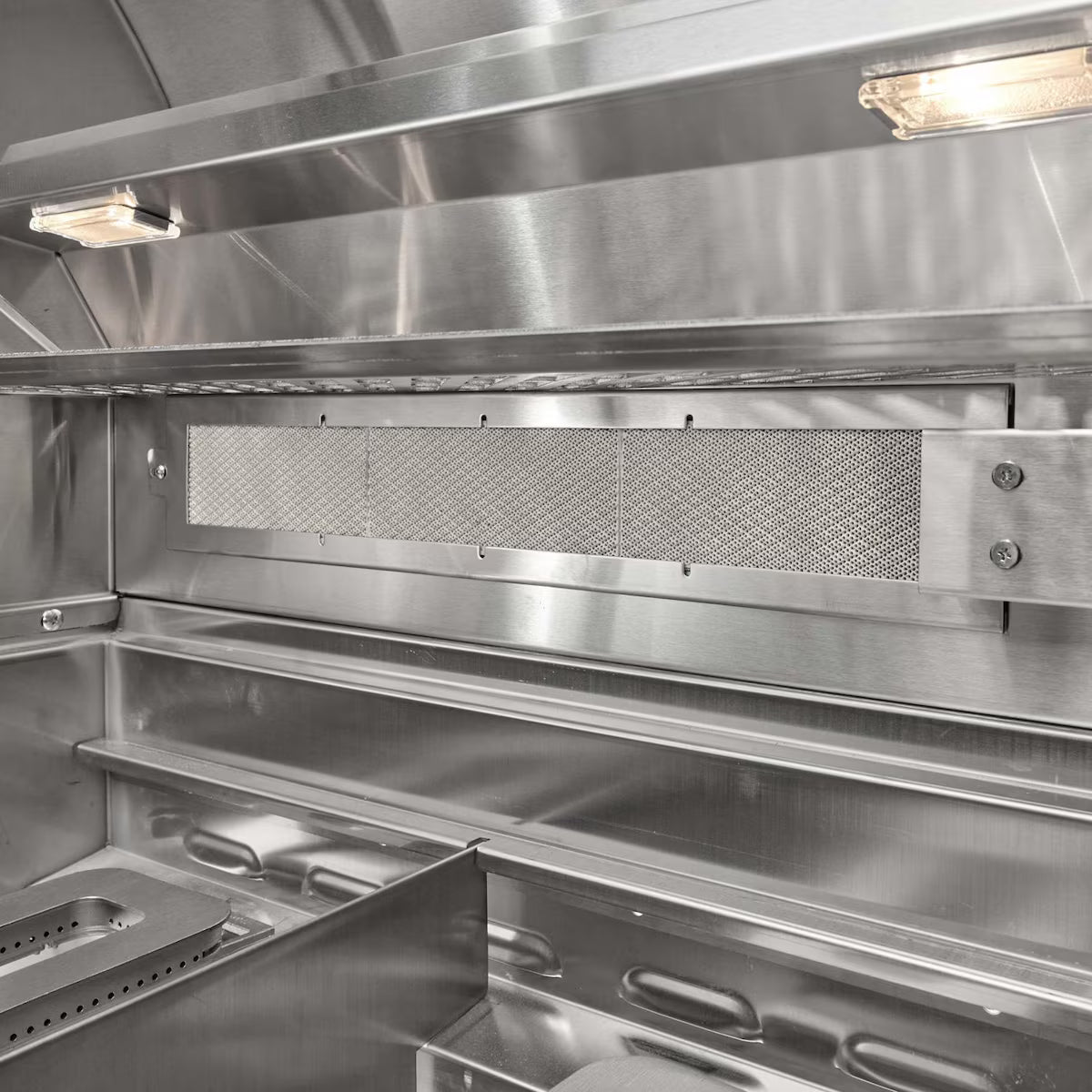 Interior view of a stainless steel grill showing the rear infrared burner mesh panel, interior light, and warming rack