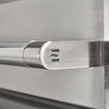Close-up of the polished stainless steel tubular grill handle end cap with an embossed wave logo, mounted on the brushed steel grill lid
