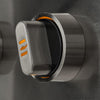Macro close-up of a single stainless steel grill control knob with an orange-illuminated indicator ring