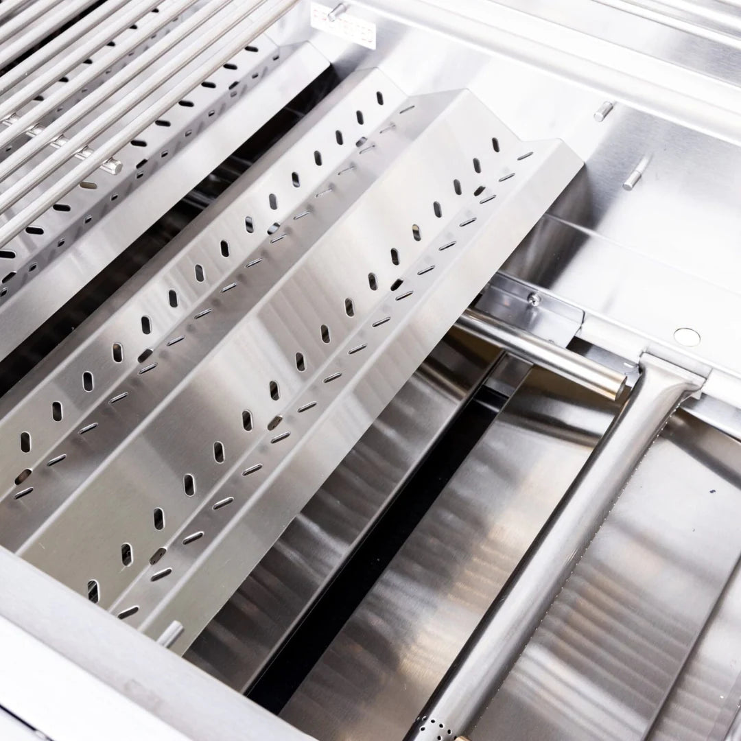 Interior of a Summerset built-in gas grill showing the stainless steel flame tamer plates over the burner