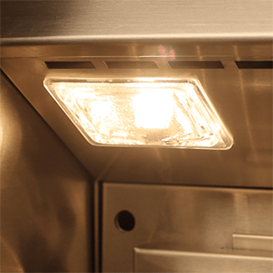 Close-up of the illuminated interior halogen light inside the hood of an Alfresco built-in gas grill