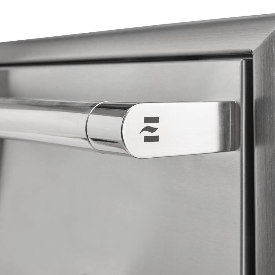 A close-up of the stainless steel tubular bar handle on a Coyote outdoor kitchen cabinet, showing the Coyote logo emblem on the end of the handle