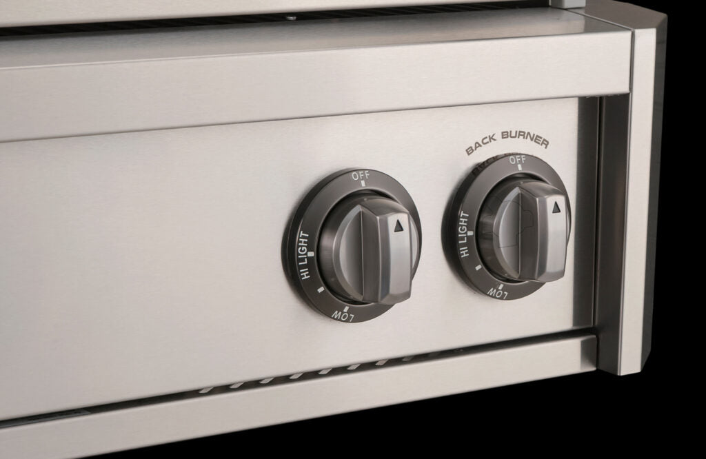Close-up of an AOG built-in grill's stainless steel control knobs, including the back burner ignition knob