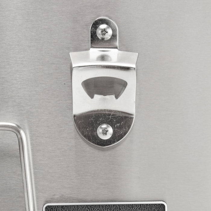 A close-up of the built-in stainless steel bottle opener mounted on the front of the Coyote 30-inch refreshment center, against a brushed stainless surface