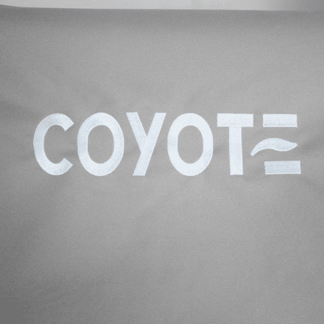 A close-up of a gray Coyote protective cover for an electric grill, with the white Coyote logo printed on the fabric