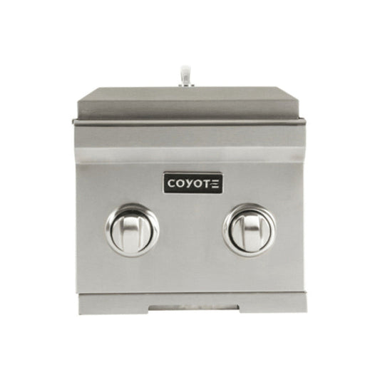 A stainless steel Coyote built-in double side burner with the lid closed, two round control knobs and the Coyote logo on the front panel, shown front-on against a white background