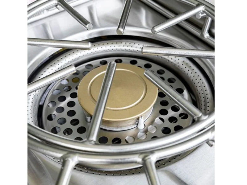 Close-up of a power burner's brass burner head, perforated bowl, and round cast iron grate