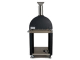 A black dome-top wood-fired outdoor pizza oven with a stainless steel chimney, mounted on a black cart stand with an open lower shelf and caster wheels, shown front-on against a white background