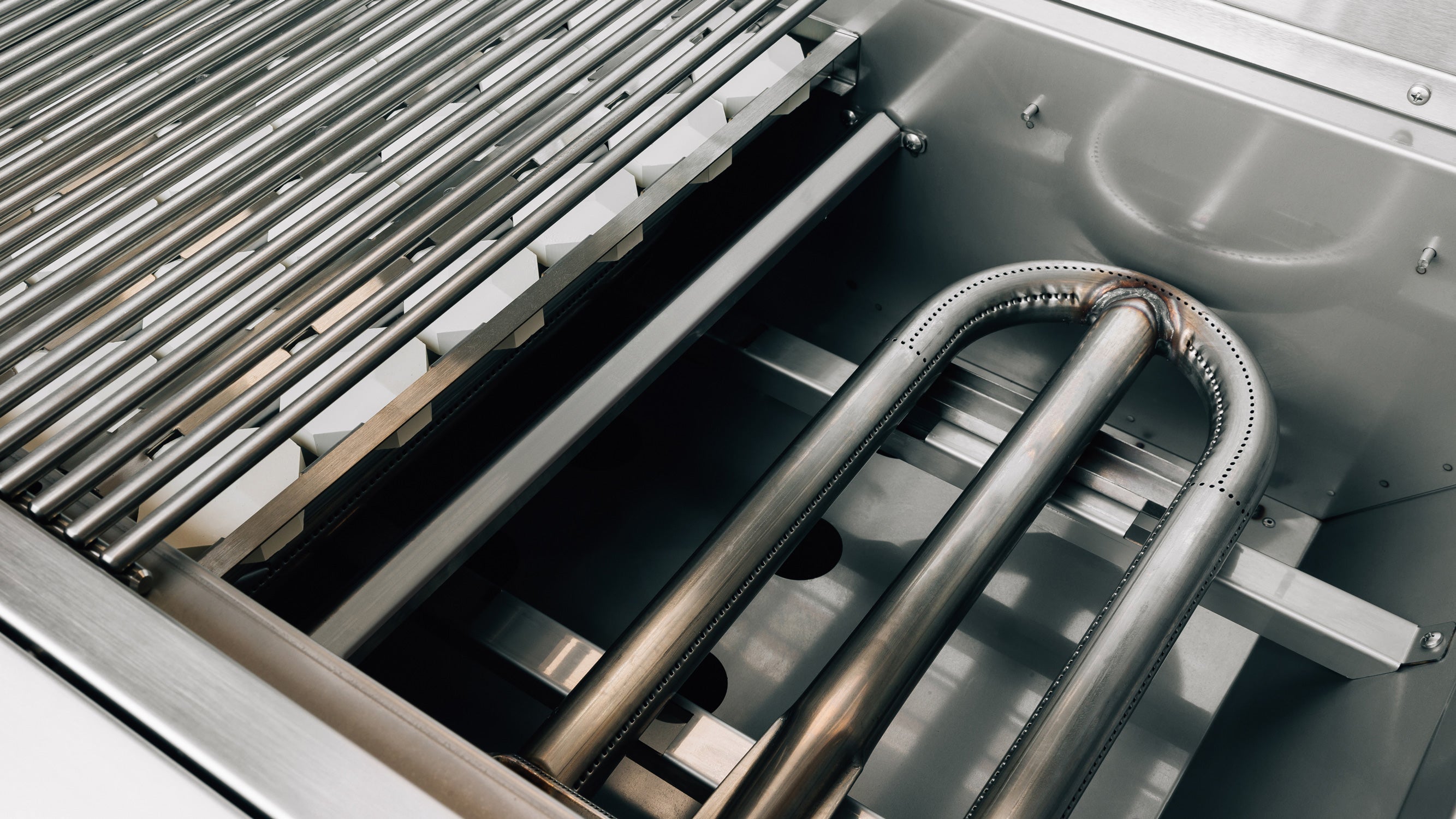 American Made Grills Alturi 30-inch built-in gas grill — cooking grate lifted to show the U-tube burner