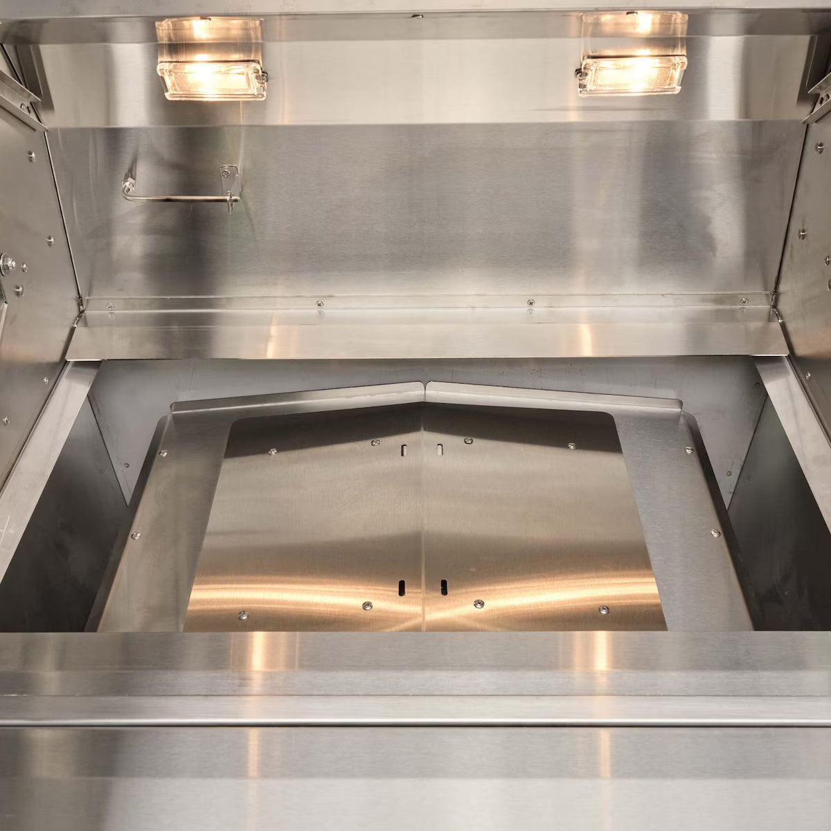 Stainless steel interior firebox and drip tray of Coyote outdoor grill