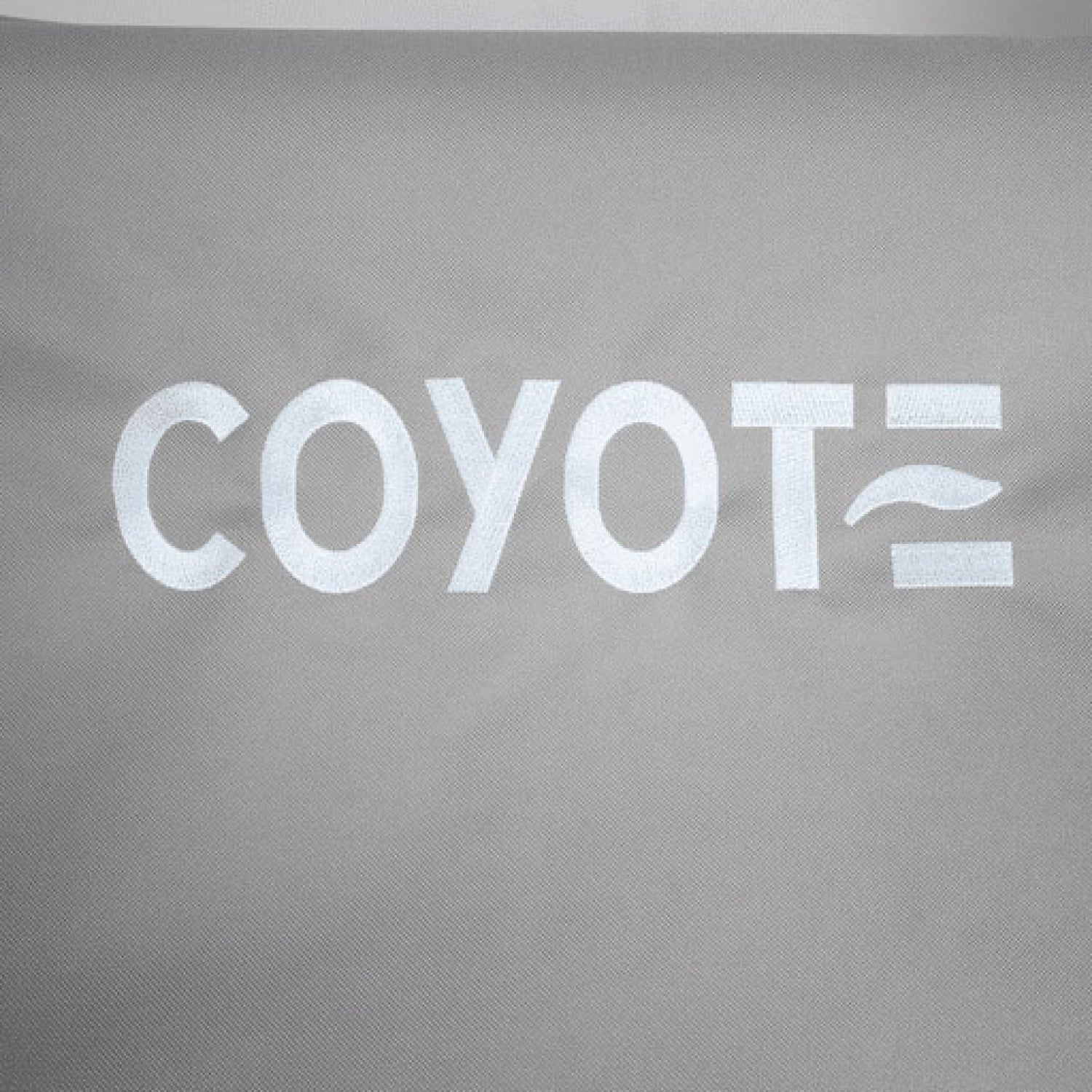 White Coyote logo printed on gray grill cover, close-up view