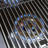 Close-up of a lit side burner with blue flames seen through the stainless steel cooking grate