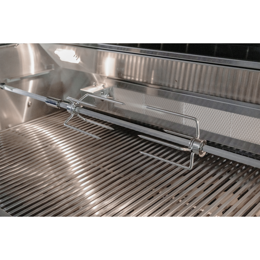Close-up interior of a Renaissance Cooking Systems grill showing the stainless steel rotisserie spit rod and forks above the cooking grates with the rear infrared burner