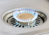 Alfresco 24-inch Versa Power cooker with the independent center burner lit under the brass cap, AIPGVP