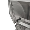 Close-up of a stainless steel grill lid hinge and its coil spring mechanism, with the firebox and cooking grates partly visible, on a white background
